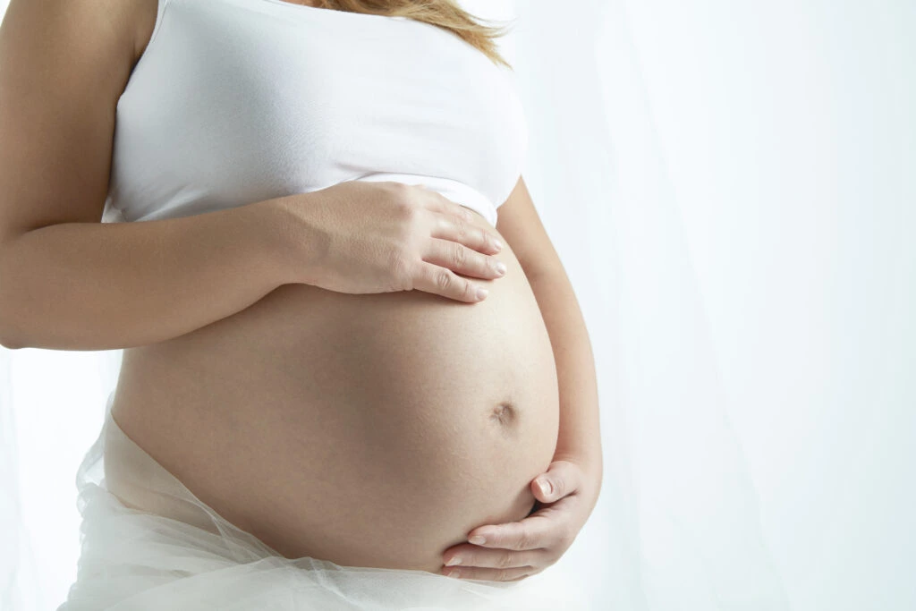 réflexologie pédiatrique deux pied de bébés sont tenus dans des mains adultes.
