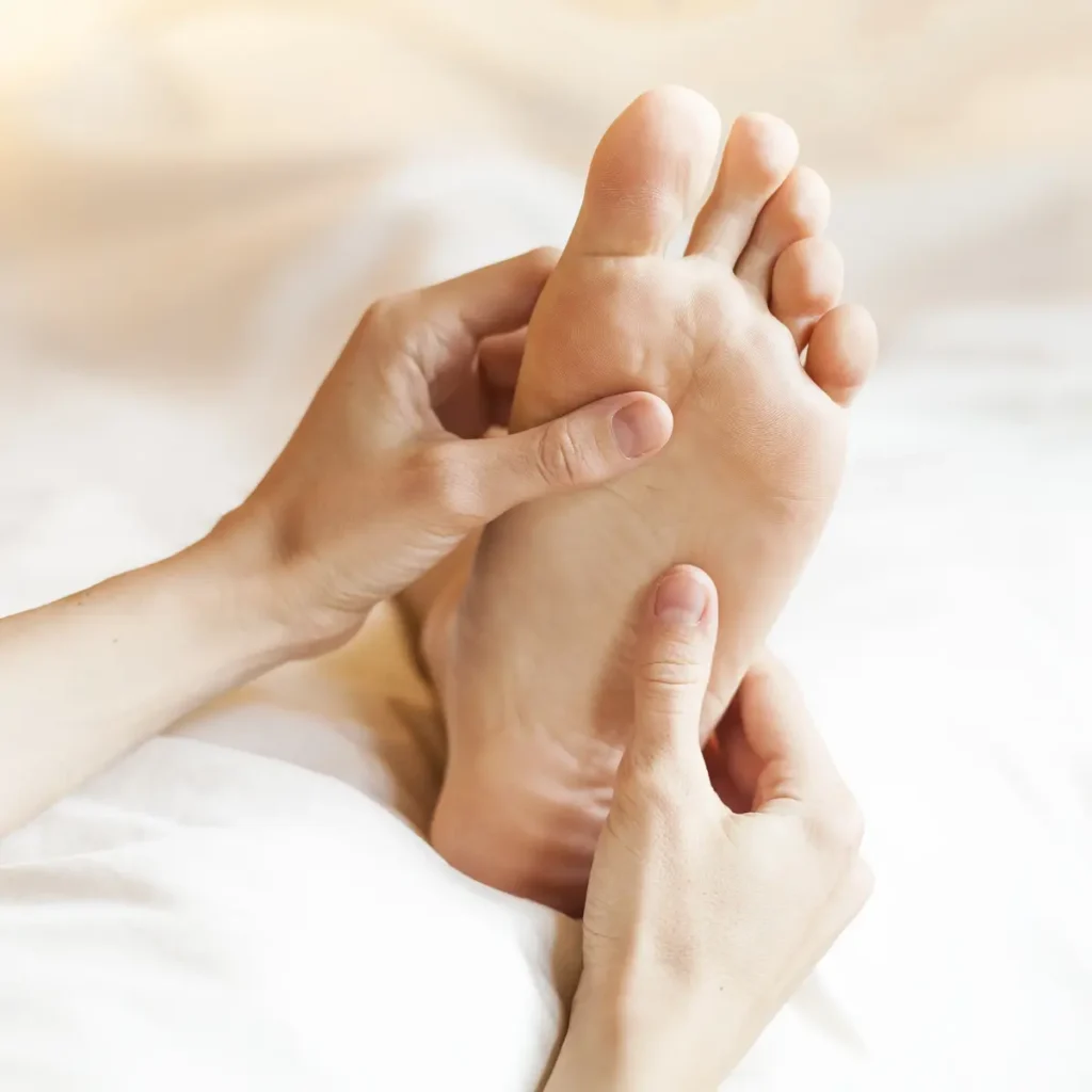 un pied gaude se fait masser par un réflexologue